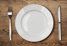 White Empty Dinner Plate Setting On Wooden Table