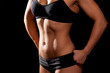 © hamara - Sporty female body on black background