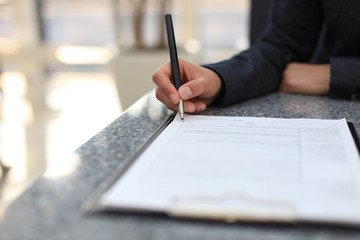 Businesswoman sitting at office desk signing a contract