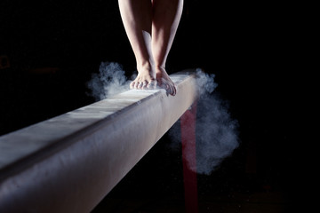 feet of gymnast on balance beam