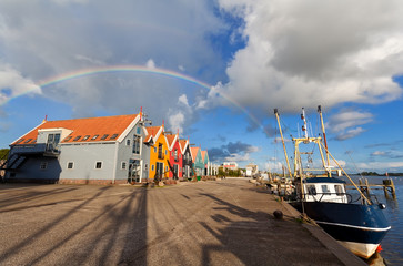 Fototapete - rainbow over harbor in fishing village Zoutkamp