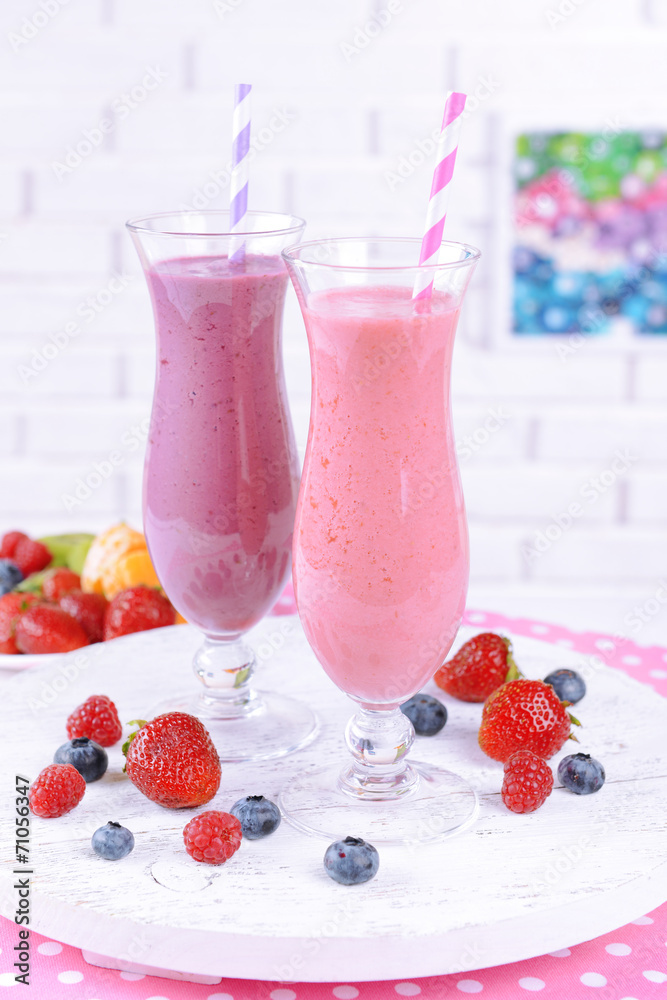 Delicious berry cocktails on table on brick wall background