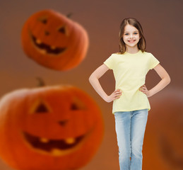 Canvas Print - smiling girl over pumpkins background