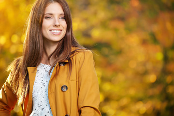 Sticker - Beautiful elegant woman standing in a park in autumn