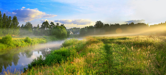 panorama of a summer landscape with sunrise, fog and the river
