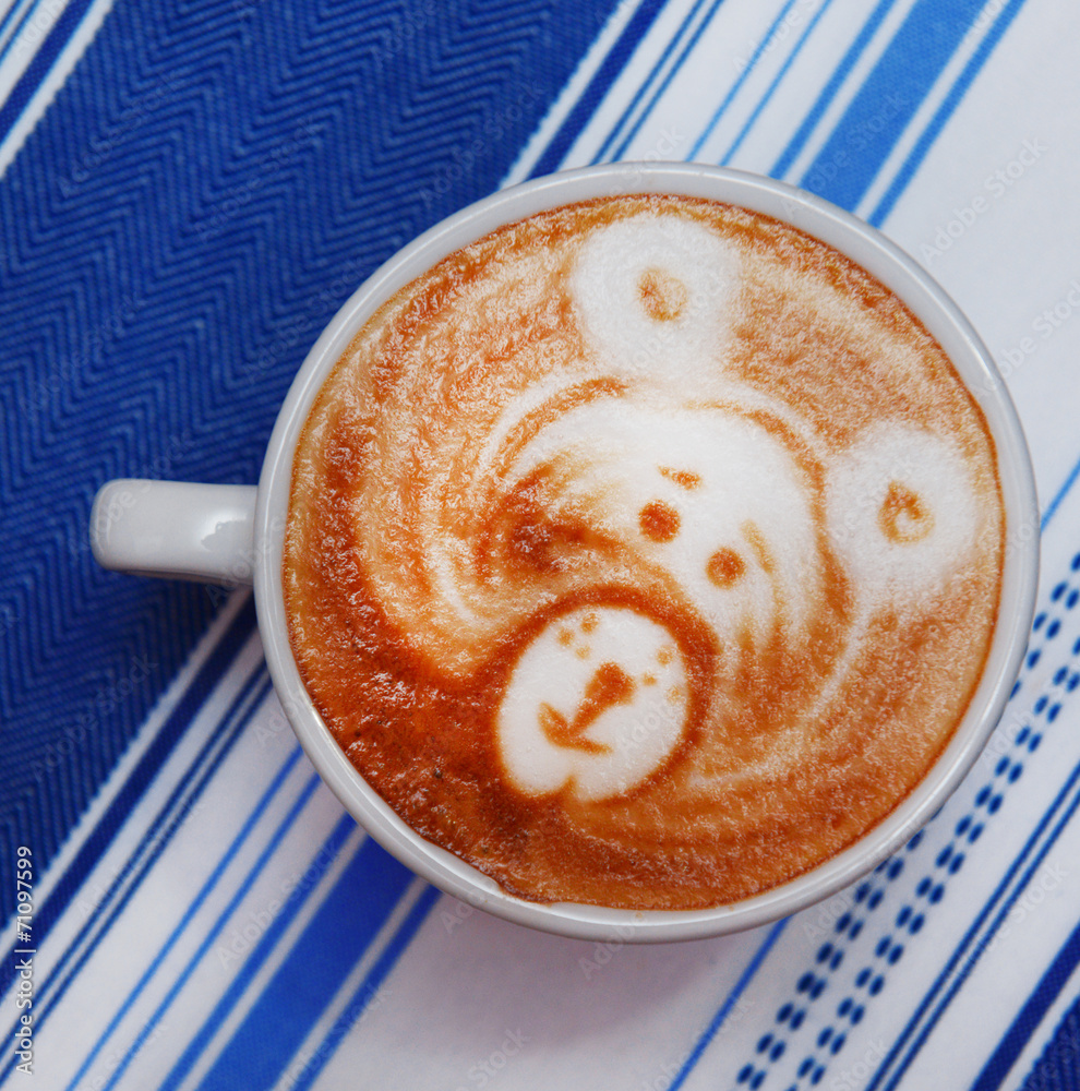 Cup of coffee with cute drawing in cafe