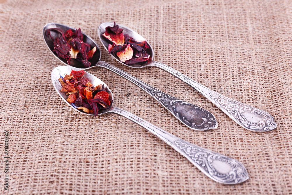 Tea in spoons on sackcloth fabric background