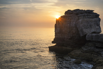 Wall Mural - Beautiful rocky cliff landscape with sunset over ocean