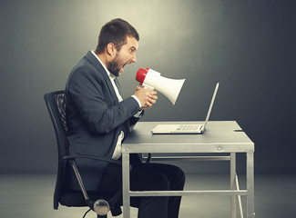 Wall Mural - aggressive man screaming at laptop