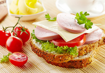 Wall Mural - breakfast sandwich with sliced sausage and tomato