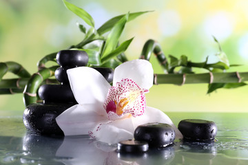 Wall Mural - Spa stones and white orchid on table on natural background