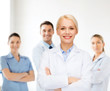 © Syda Productions - smiling female doctor with group of medics