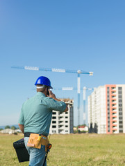 Canvas Print - back view of male engineer talking on phone construction site