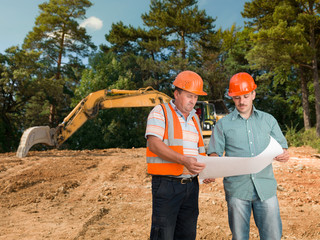 engineer discussing plan with construction worker