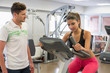 © onoky - Instructor teaching a woman in spinning class at gym