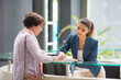 © onoky - Woman signing paper at reception desk