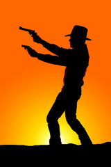 Wall Mural - cowboy silhouette with two pistols sunset