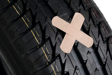 black new tire with patch on white