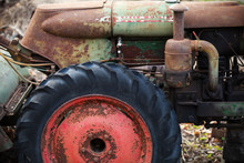 Fragment Of Old Rusted Green Tractor With Red Wheel