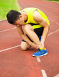 © Tom Wang - young male runner with ankle injury on track