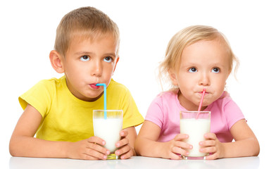 Cute little girl and boy are drinking milk