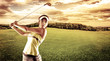 Young female golf player swinging with golf club outdoors