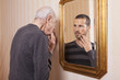 young man looking at an older himself in the mirror