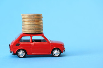 Coins on red miniature car