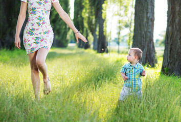 Beautiful mom playing in the park with her kid