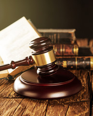 Wooden gavel and books on wooden table, law concept