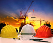 © stockphoto mania - safety helmet on civil engineer working table against crane lift