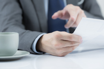 Businessman at the workplace drink coffee and looking some busin