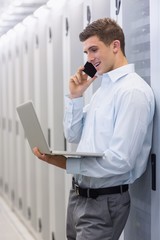 Poster - Smiling technician phoning and using his notebook