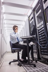 Poster - Technician talking on phone while diagnosing servers