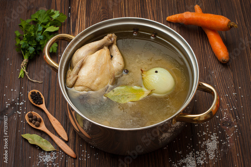 Fototapeta na wymiar chicken broth with vegetables and spices in a saucepan