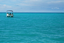 A Single Pontoon Boat In A Calm Tropical Sea