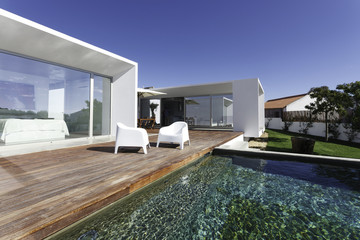 Modern house with garden swimming pool and wooden deck