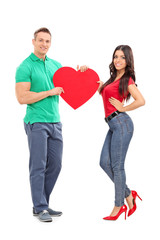 Wall Mural - Young couple holding a big red heart