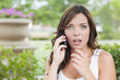 © Andy Dean - Shocked Young Adult Female Talking on Cell Phone Outdoors