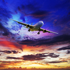 Fototapete - Jet plane in a spectacular sunset sky