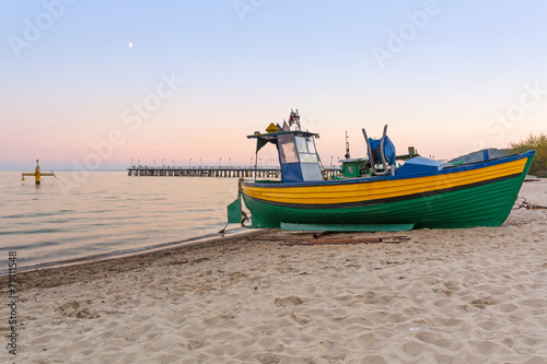 Nowoczesny obraz na płótnie Baltic beach with fishing boat at sunset, Poland