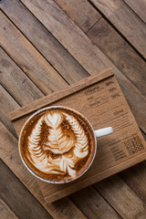 Wall Mural - Cup of hot latte art coffee on wooden table