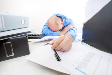 Wall Mural - Overworked and tired businessman at the office