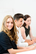 © W PRODUCTION - cheerful young business woman with partners in  meeting room