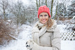 canvas print picture - Glückliche Frau im Winter steht im Garten