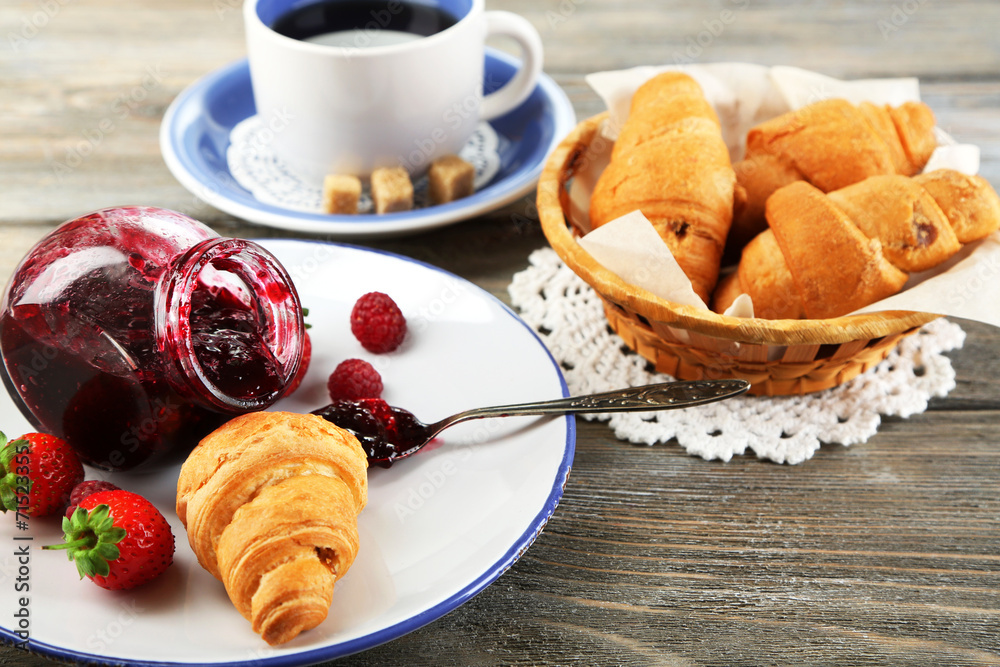 Breakfast with tea, raspberry jam and fresh croissants