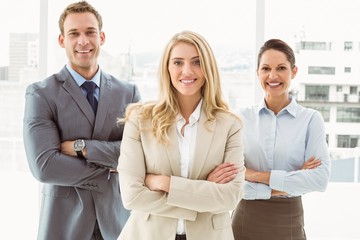 Wall Mural - Young business people with arms crossed in office