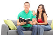 © Ljupco Smokovski - Young couple reading a book seated on sofa