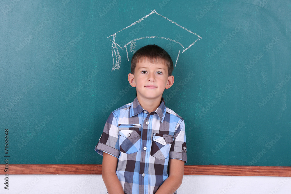 Schoolboy at blackboard in classroom