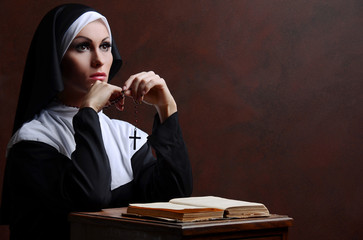 Young attractive nun praying